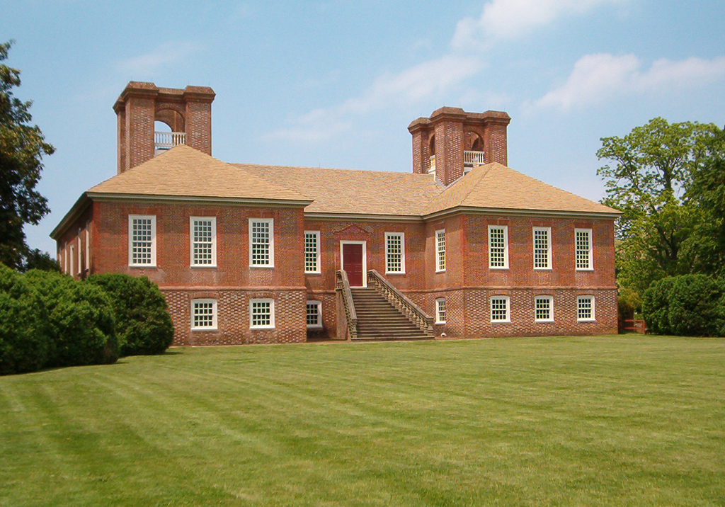 Red brick façade of the Stratford Hall building on a green lawn and garden.  