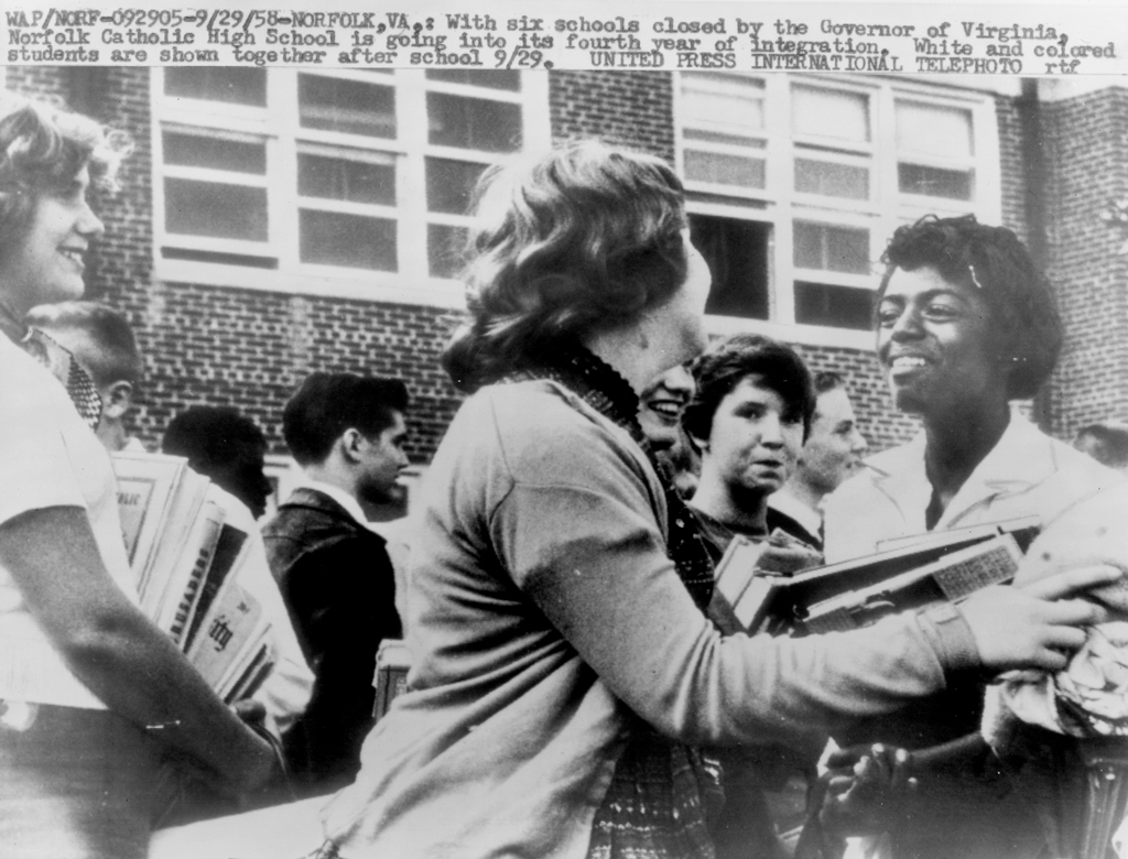 White students at Norfolk Catholic High School greet a black peer with smiles, in 1958.