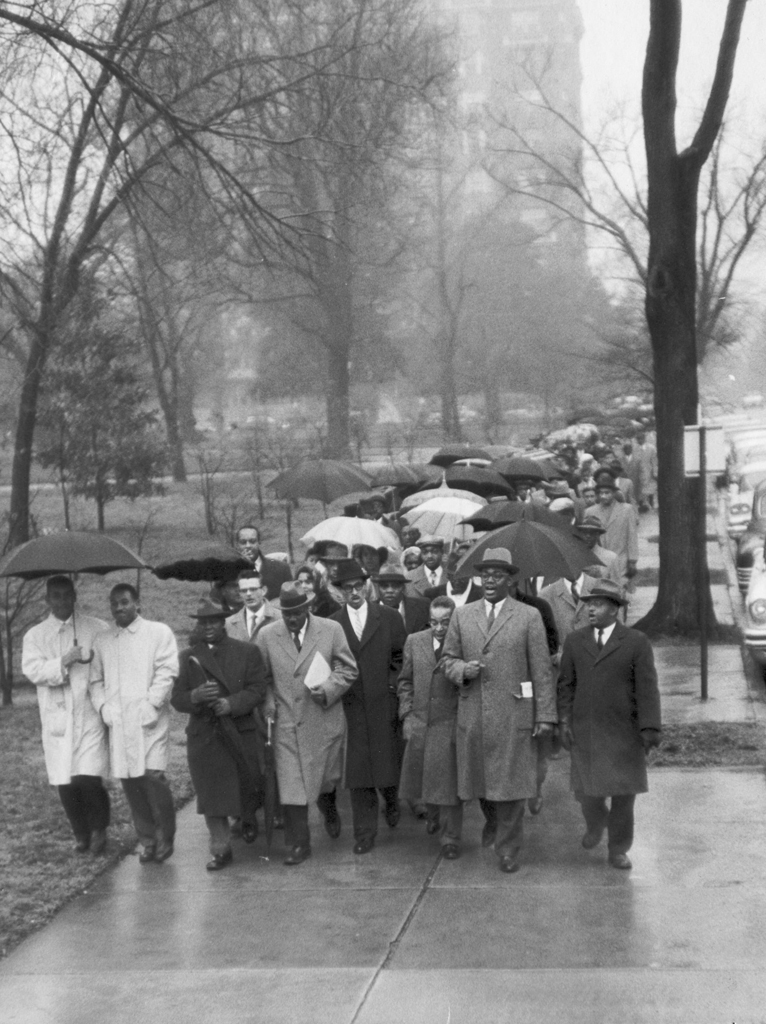 A large group of demonstrators holding umbrellas walking down the street in the rain in Richmond, Virginia, January 1, 1959 
