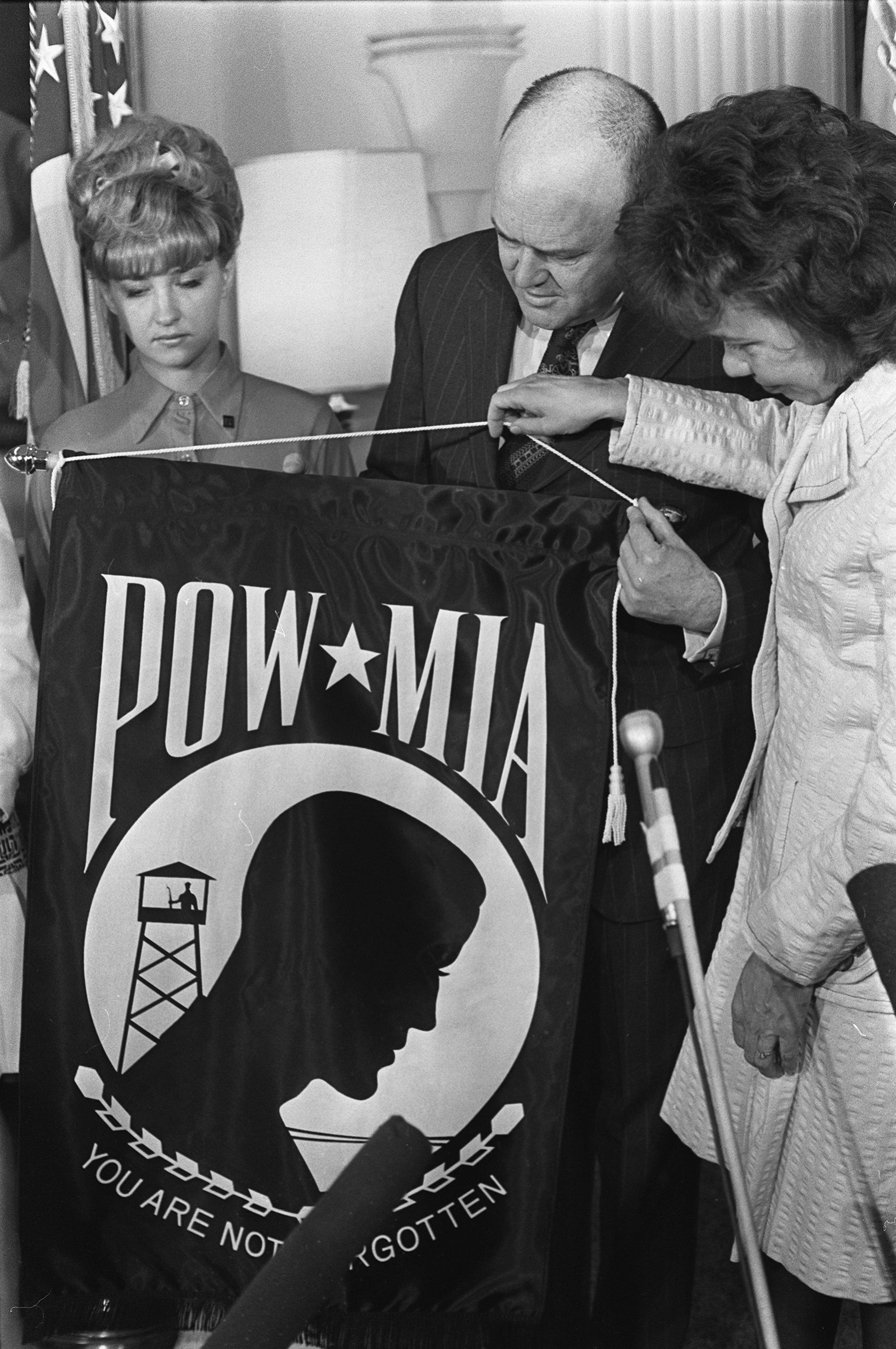 Air Force POW wife and National League member Evelyn Fowler Grubb (right) presents the flag of the National League of Family Members of Prisoners of War and Missing in Action in Southeast Asia to Secretary of Defense Melvin Laird in 1972. POW mother Jean Ray looks on. Image courtesy of the Associated Press.
