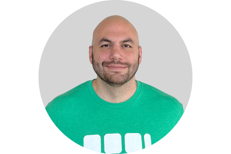  Headshot of Dan Giusti - a white ban with bald head and light beard in a green t shirt