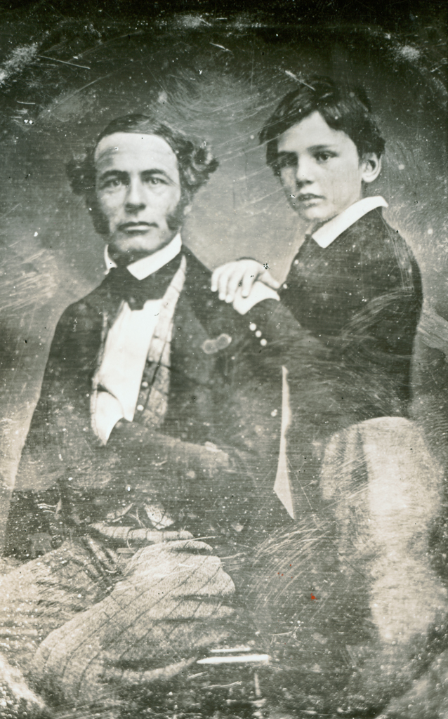 Black and white photograph of a seated Robert E. Lee posing with his son William Henry Fitzhugh Lee standing behind him with his hands placed on his father’s shoulder.  