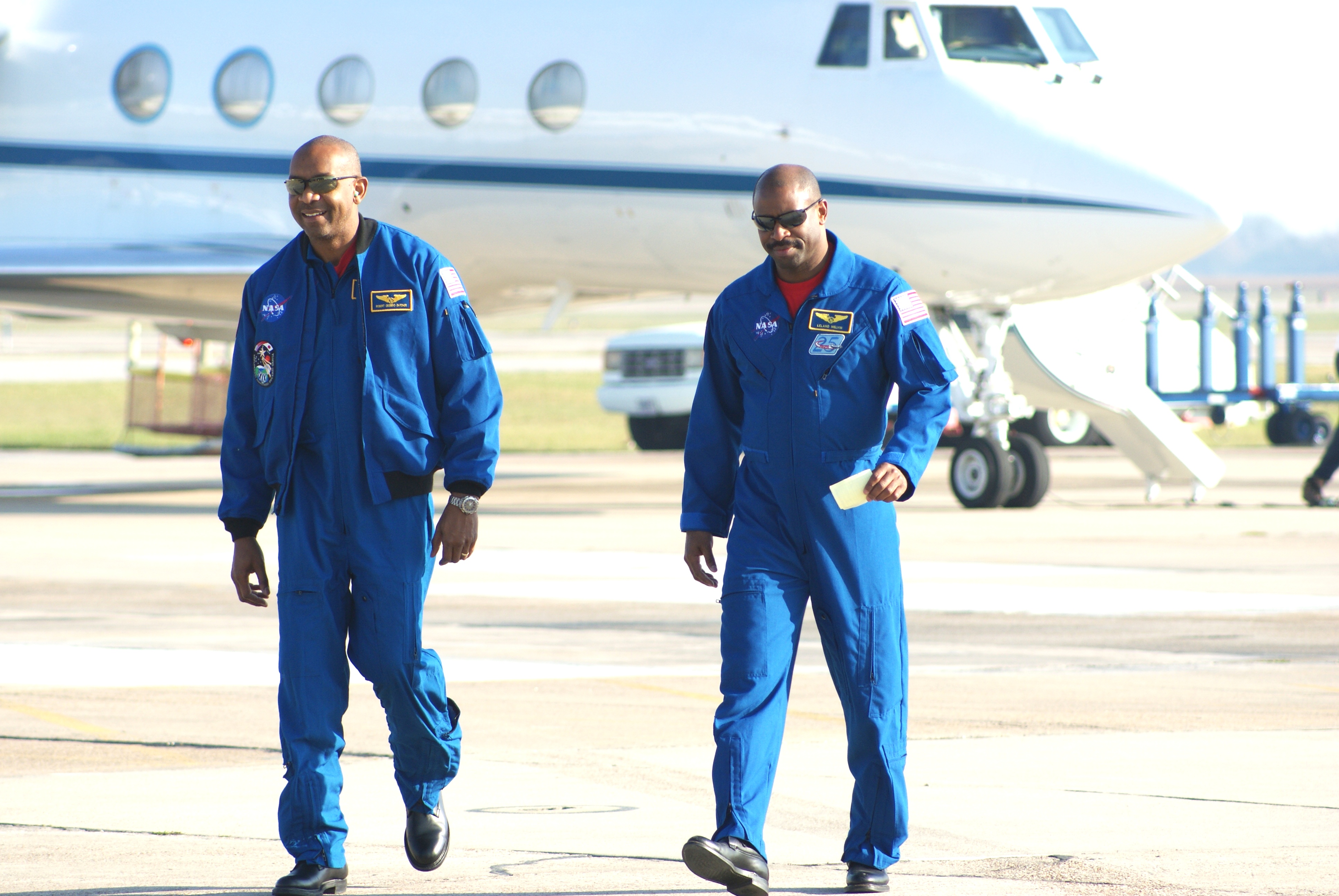 Leland Melvin and Dr. Robert Satcher, two Black NASA astronauts walk on the tarmac