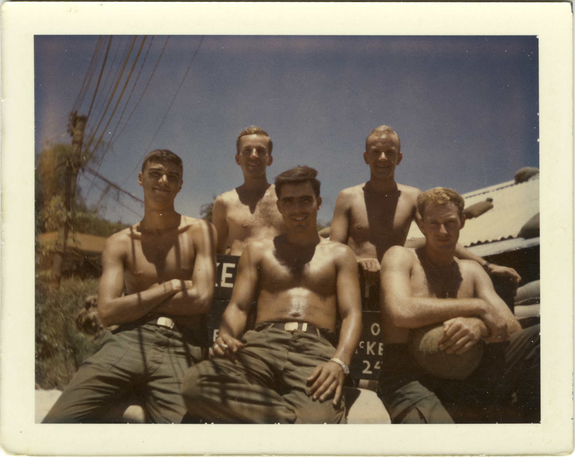 A group of five soldiers, shirtless and wearing green fatigue pants