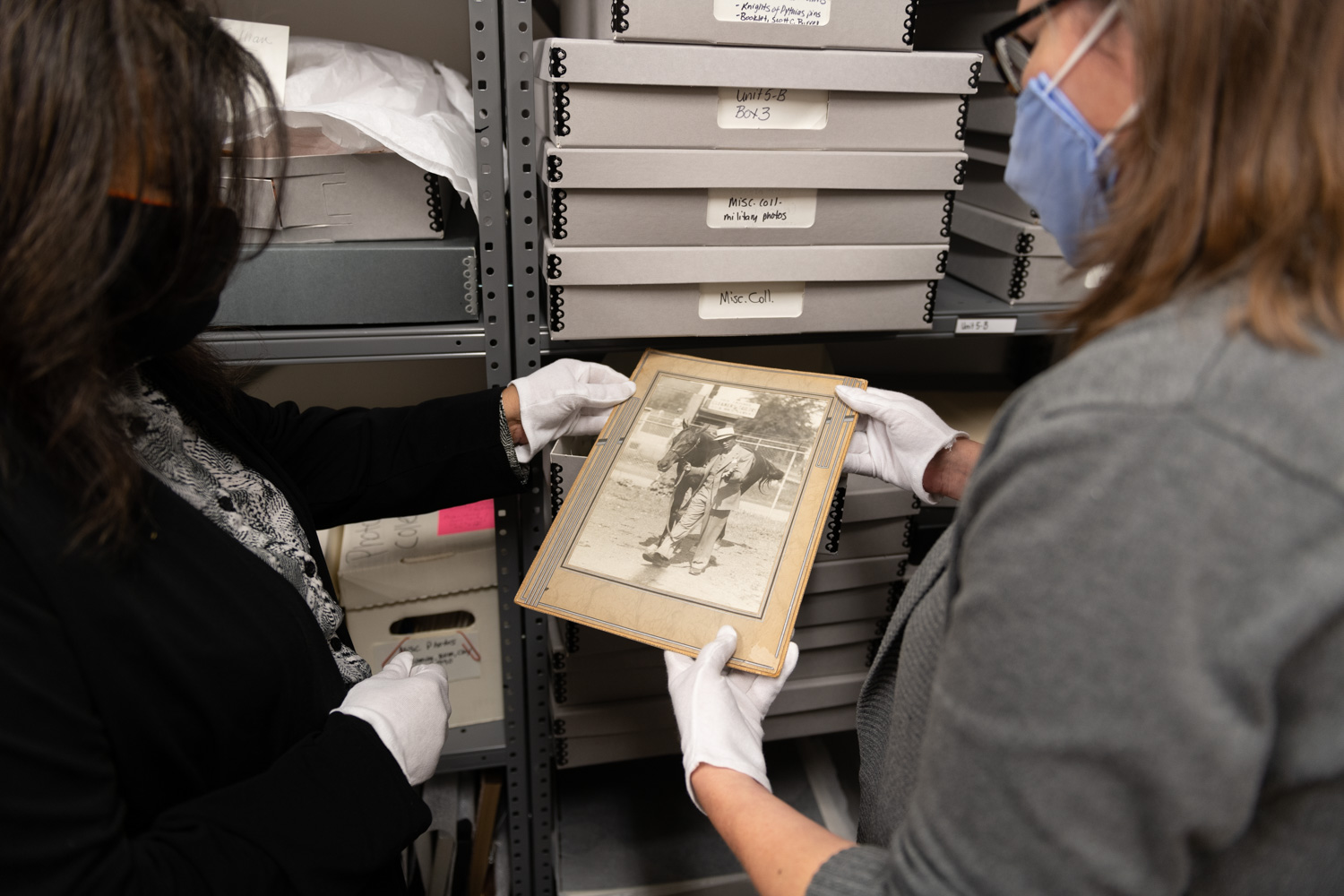Two curators examine a photograph