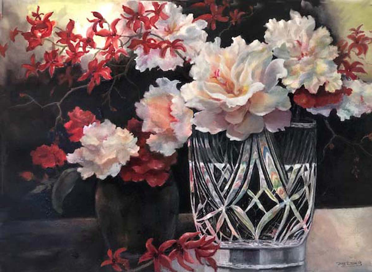 Pink and white peonies sit in a crystal vase, with more flowers in the background