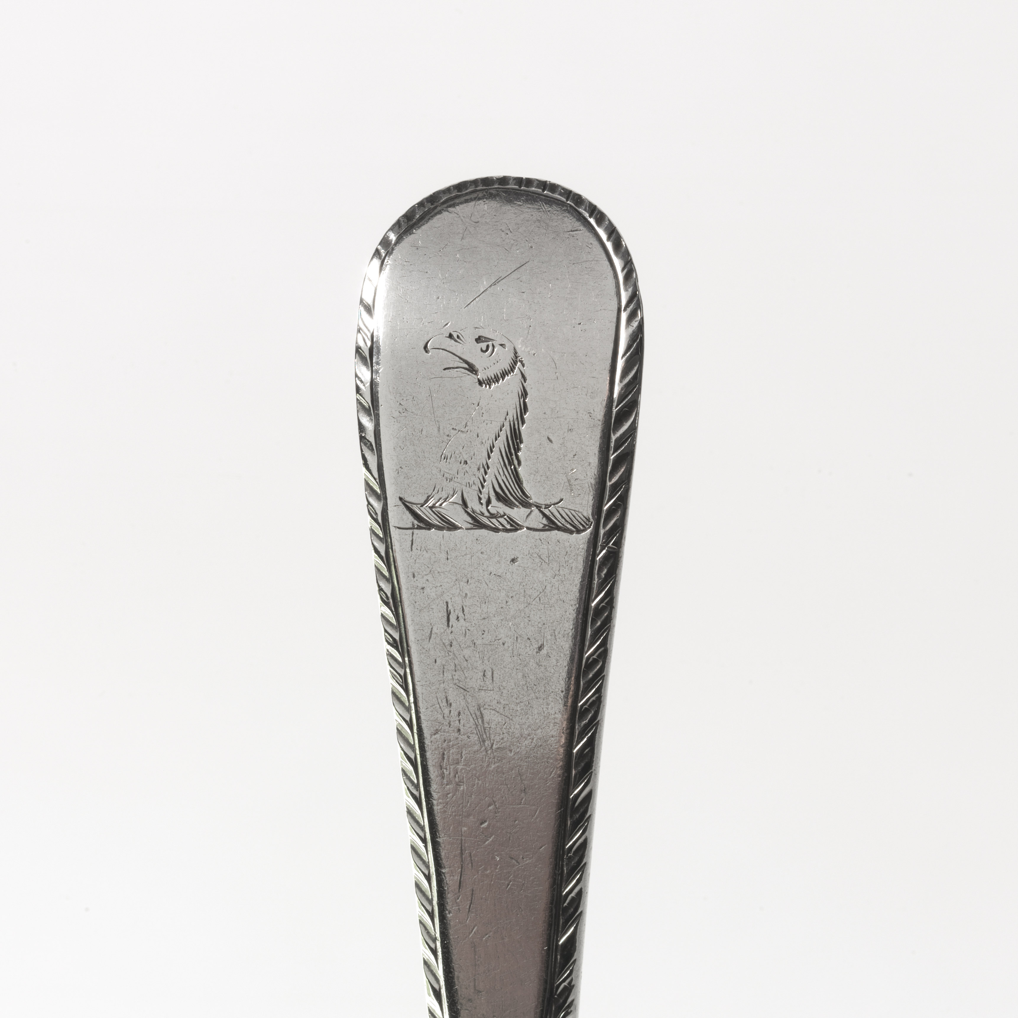 A snake engraved on a silver spoon handle