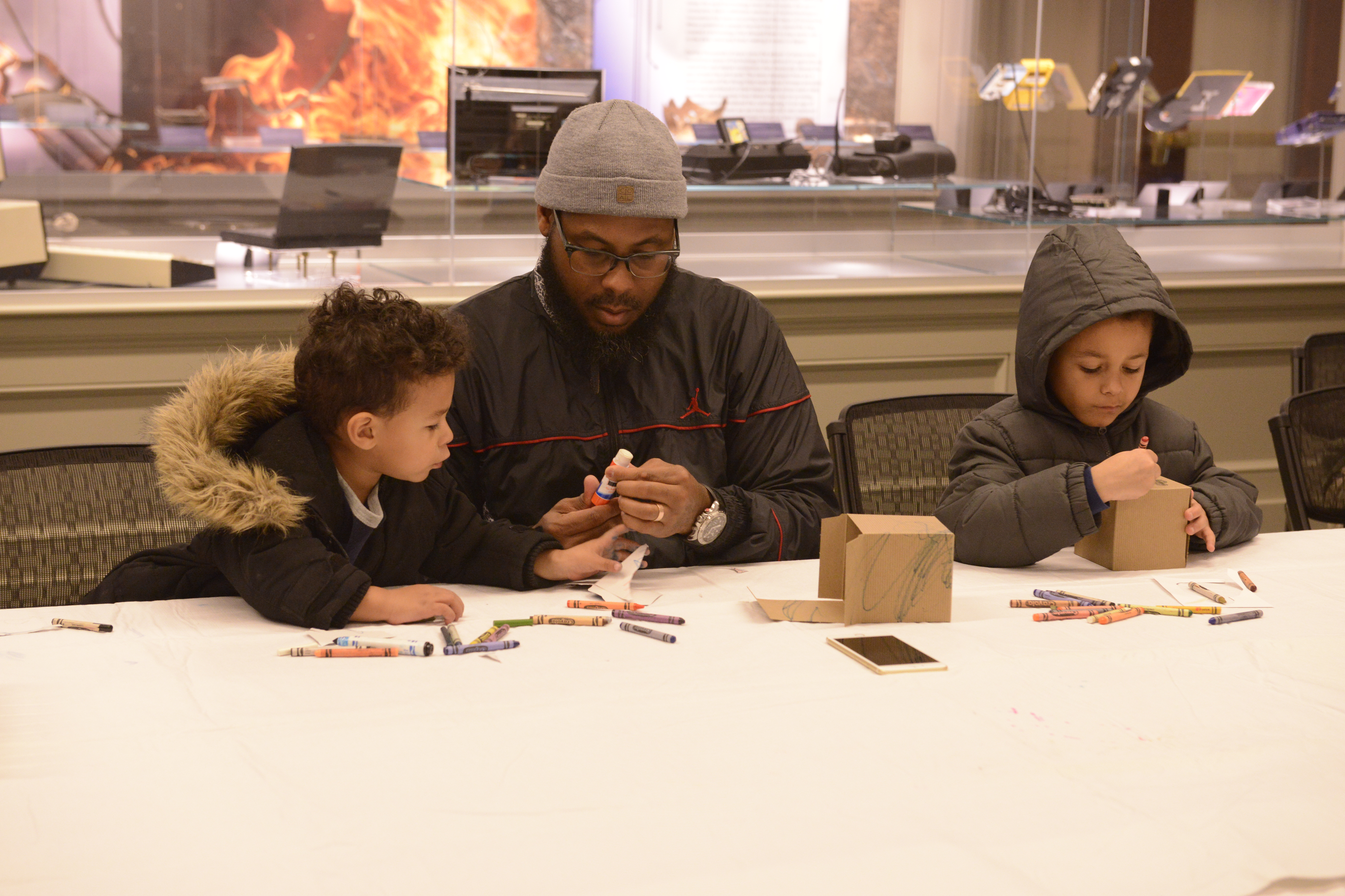 Kids and a parent enjoy a craft during Stories at the Musuem 
