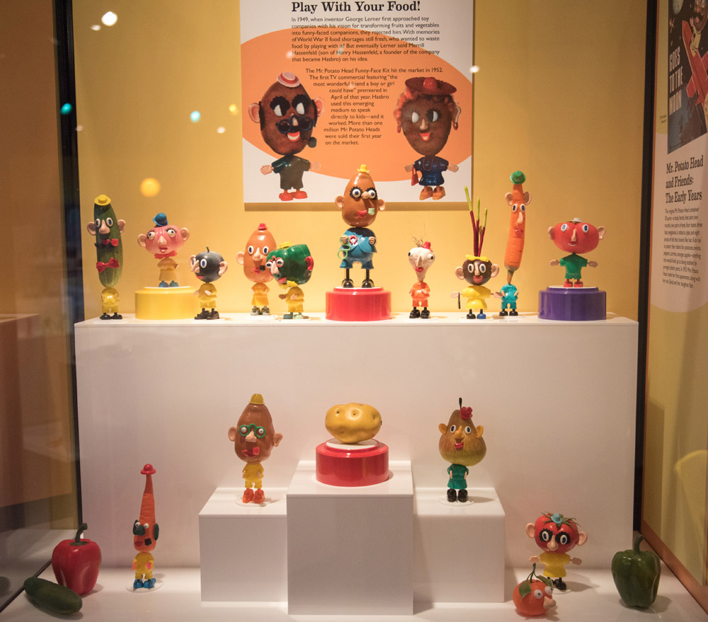 A display case filled with various Mr. Potato Head toys
