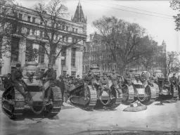 Black & White photo of a row of tanks in front of a building circa 1912-1914