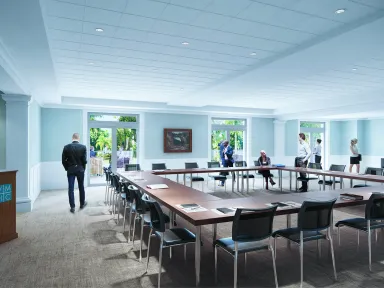 A rendering of a meeting room with tables and chairs arranged in a square in the center of a windowed room.