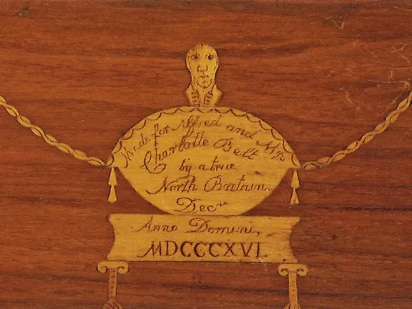 A detail of gold embellishment and inscription on wood