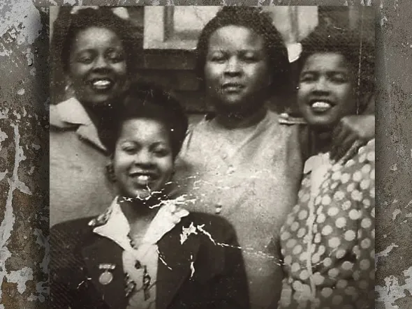 A black and white photo of four smiling women
