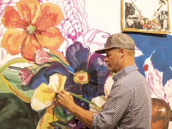 Ed Trask paints a mural of flowers