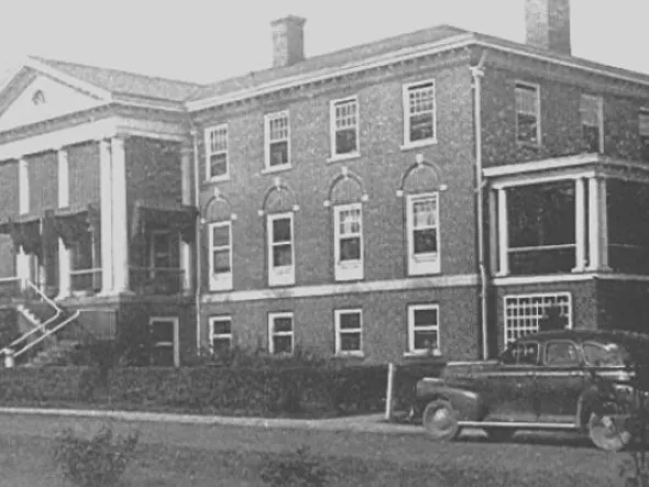 Here2Hear A black and white photo of a columned three story brick building