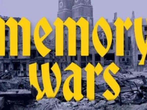 Yellow script text over a dark blue background of partially destroyed buildings reads "Memory Wars"