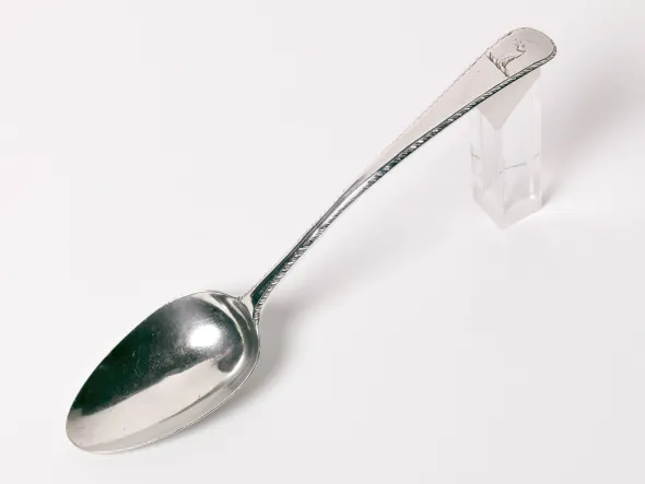 A silver spoon propped on a plastic block