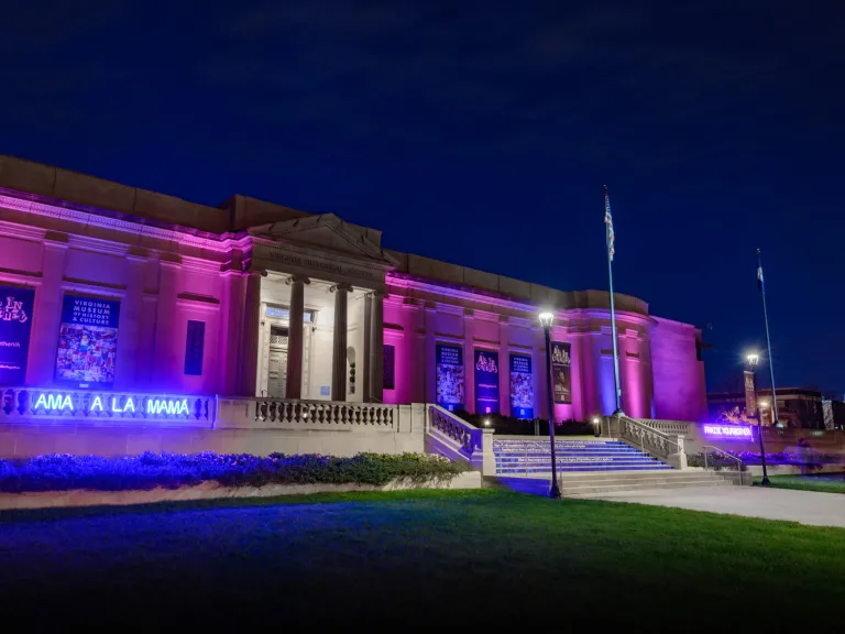 The VMHC building at night with PRAISE YOUR MOTHER / AMA A LA MAMÁ neon sign installation