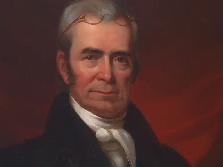 Portrait of John Marshall - Marshall has grey hair, glasses positioned on top of his head and wears a black jacket with white necktie