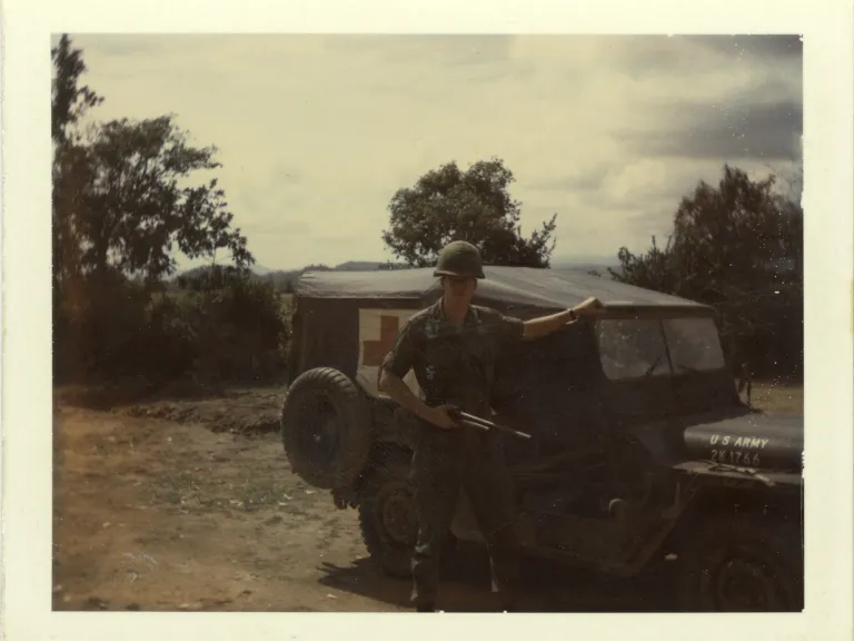 Lt. Rasmussen with the Red Cross jeep that provided a means to transport medical supplies to forward command posts. It also served as an ambulance.