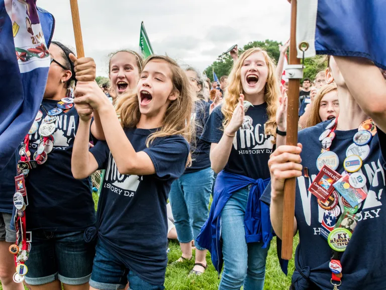 Girls holding flags celebrate at National History Day 
