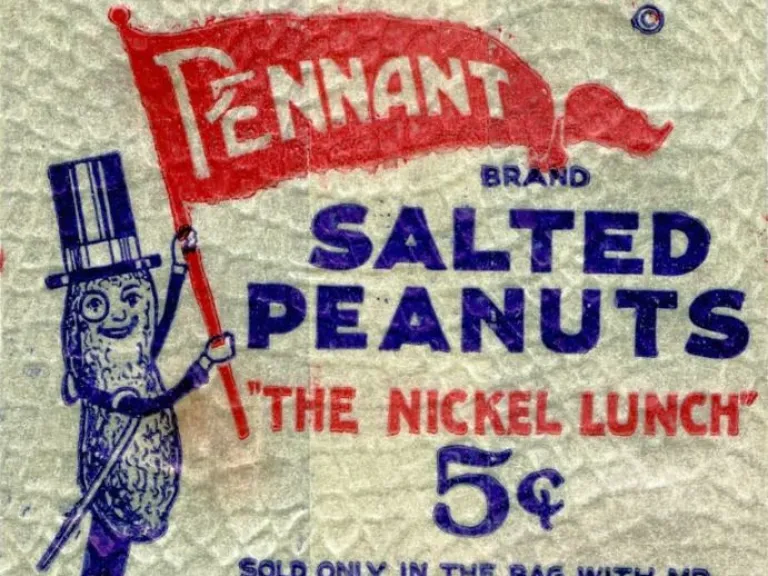 An illustrated paper bag with a cartoon of Mr. Peanut holding a red pennant. Text reads: Planters Pennant Brand Salted Peanuts, "The Nickel Lunch," 5 cents, Planters Nut & Chocolate 