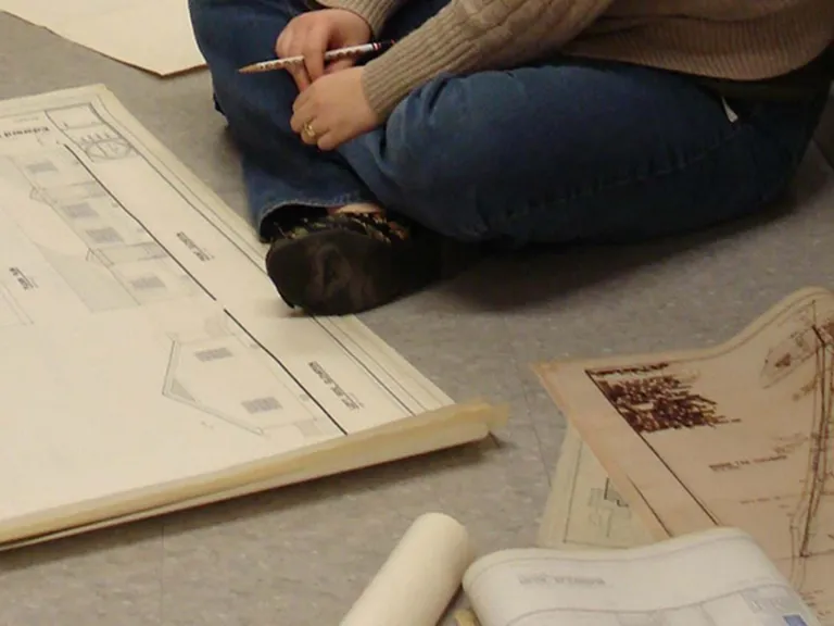 Sinnott Papers A person sits on the floor surrounded by architectural drawings