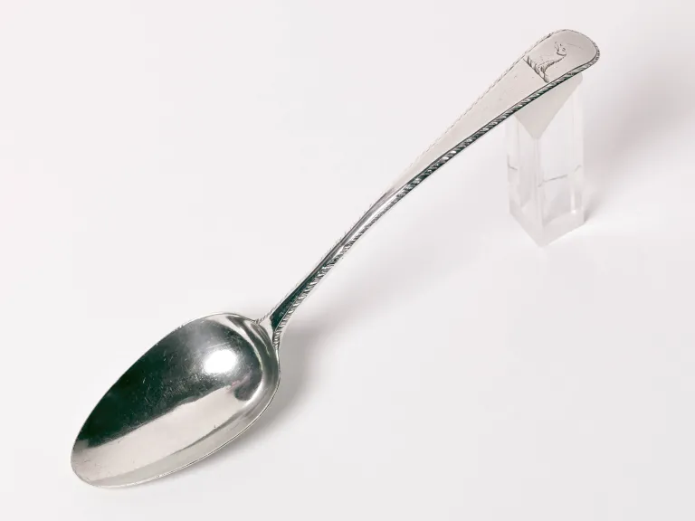 Silver Tablespoon with Custis Crest A silver spoon propped on a plastic block