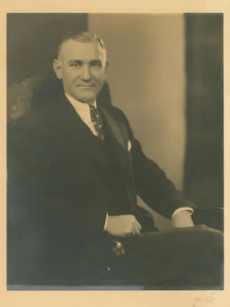 A sepia photograph of Walter L. Sams in a suit sitting in a chair