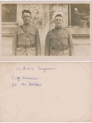 Two WWI Soldiers in uniform in front of a stone wall