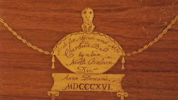 A detail of gold embellishment and inscription on wood