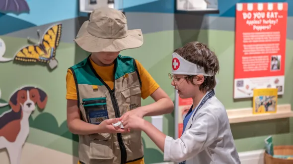 Children play with costumes of park ranger and nurse