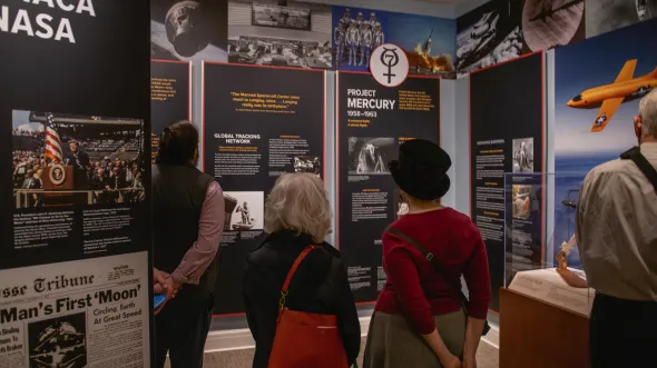 People look at panels about aviation and space exploration in a gallery