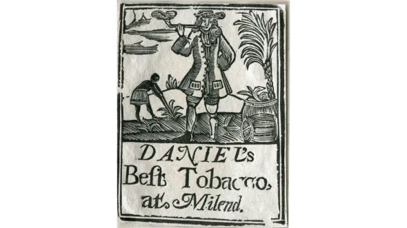 A black and white woodcut of a person in colonial garb smoking a pipe while another person picks tobacco in the background. Text reads: Tobacco label for “Daniel’s Best Tobacco at Milend” 