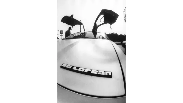 A black and white photograph of a DeLorean car.