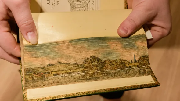 Pages ruffled farther apart show a painted landscape 