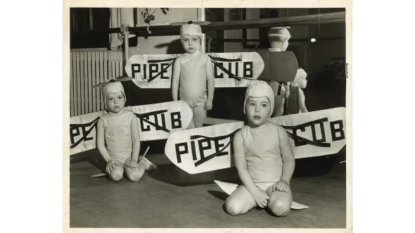 Black and white photo of three young dance students in aviation costumes.