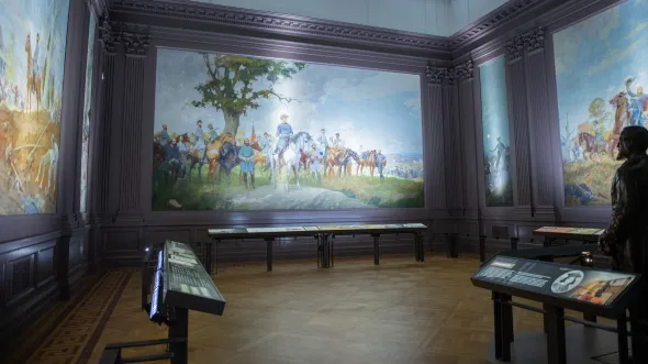 An interior view of a gallery with large scale paintings of Civil War battle scenes