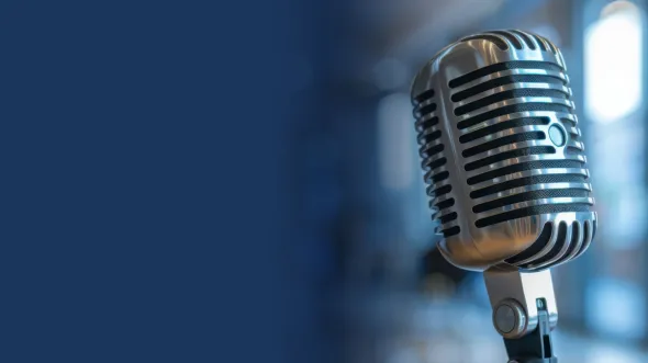 A photo of a microphone and a blue background.