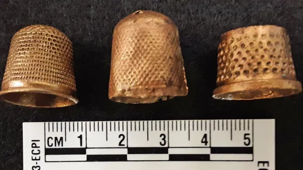 Three gold thimbles with a ruler 