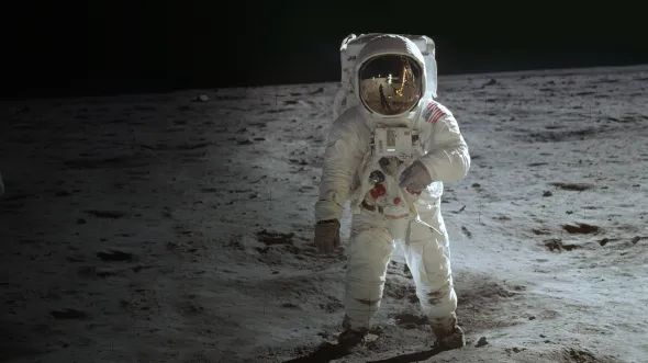 An astronaut in a space suit on the surface of the moon 