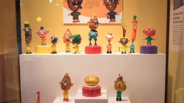 A display case filled with various Mr. Potato Head toys