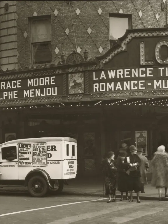 Black & white photo of Loew's Theater with white truck parked in front and people entering theater