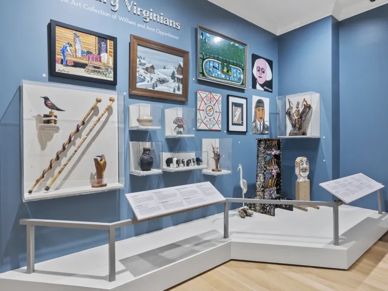 A gallery display with various folk art
