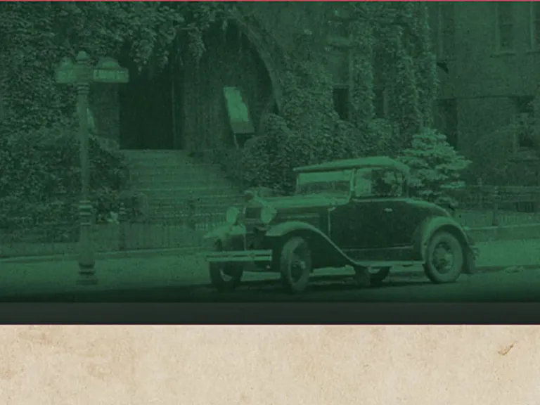 A green toned photograph of a 1940s era car in front of a stone building