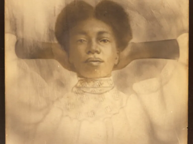 charcoal drawing of a young black woman wearing a white dress with her hands laced behind her head