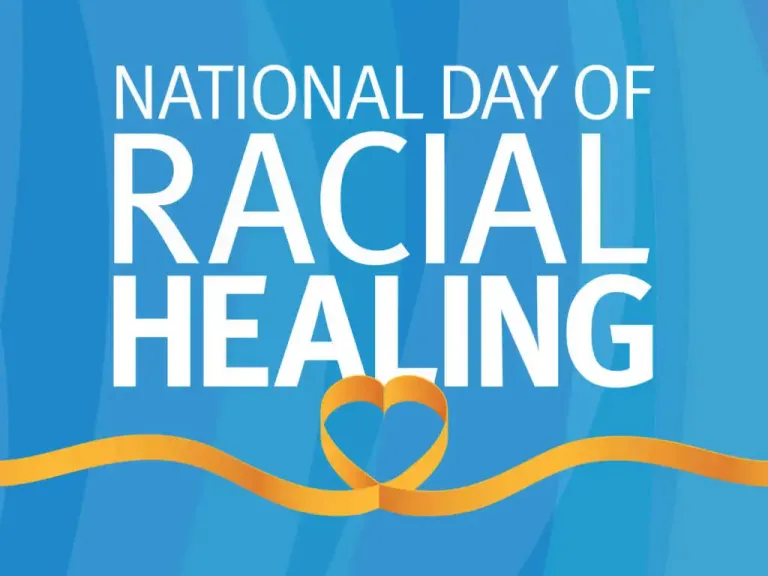 White text on a blue background reads National Day of Racial Healing. Below the words is a graphic of a yellow ribbon in the shape of a heart.