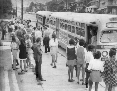 Students gathered in front of two school busses at Booker T. Washington High School