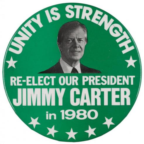 Green button with the text, “UNITY IS STRENGTH/ RE-ELECT OUR PRESIDENT JIMMY CARTER in 1980” around a black and white photograph of Jimmy Carter. 